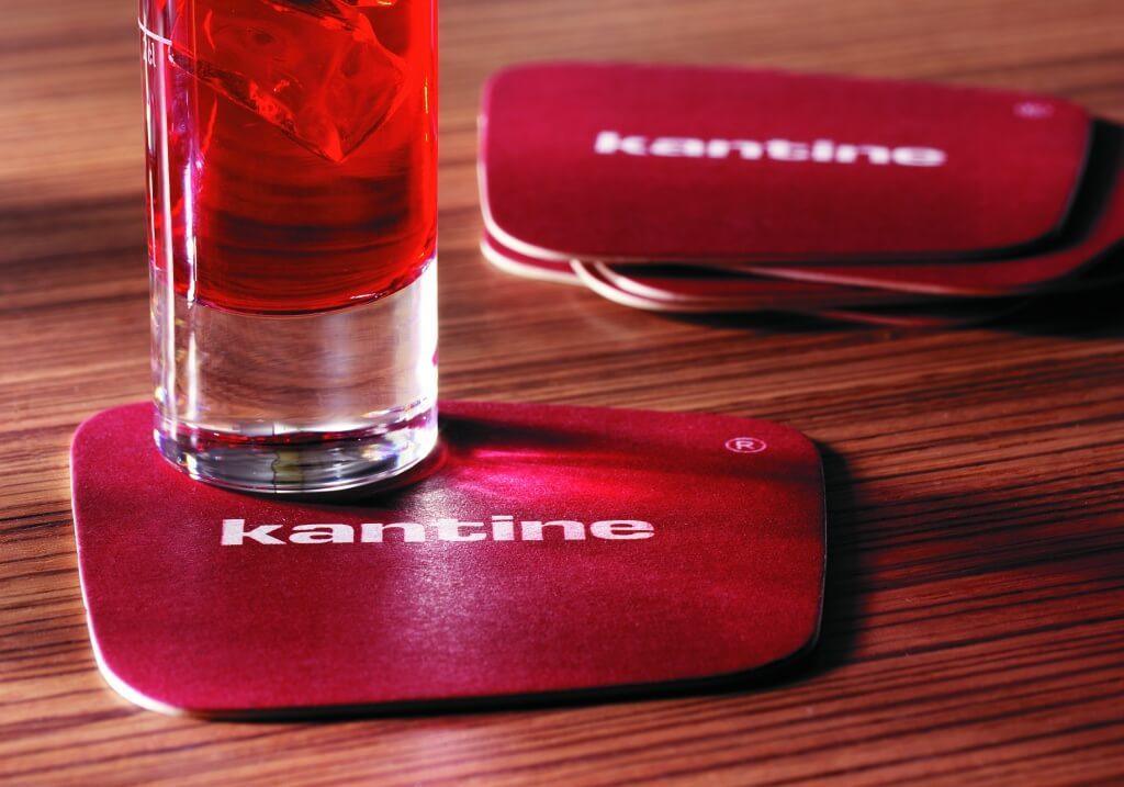 red cocktail served on a square beer mat